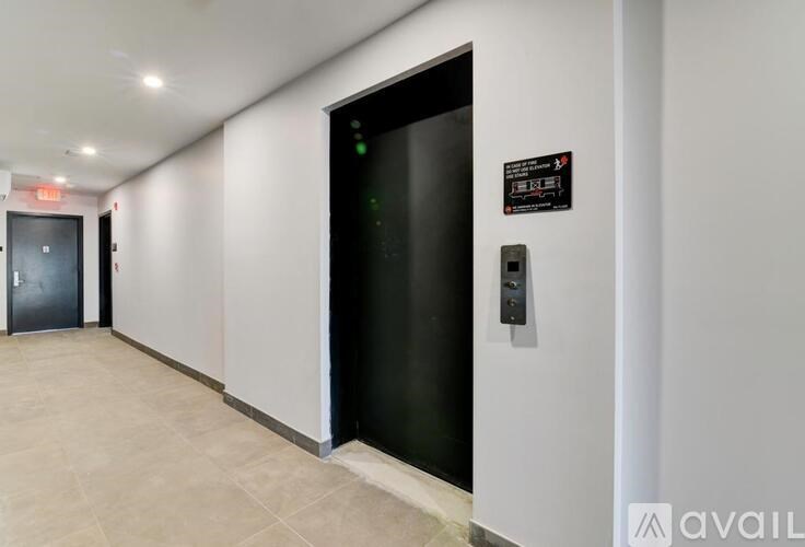 A black door with a sign on the wall next to it.