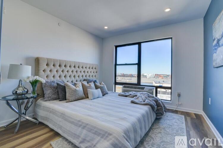 A bedroom with a large bed and a view of the city through the window.