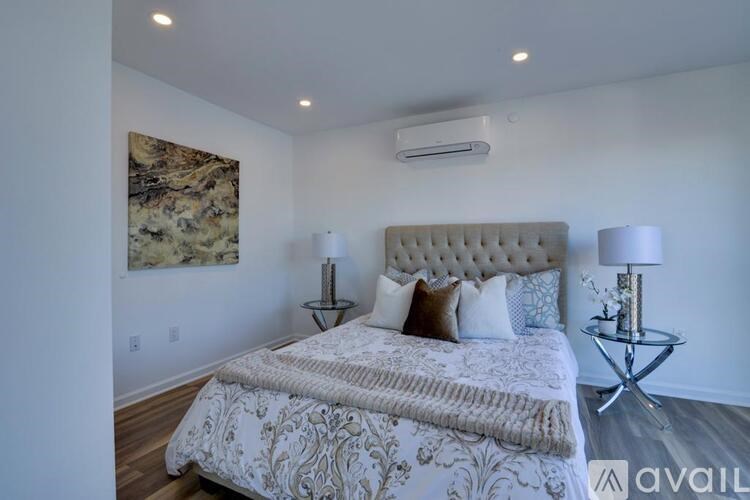 A bedroom with a large bed and a painting on the wall.