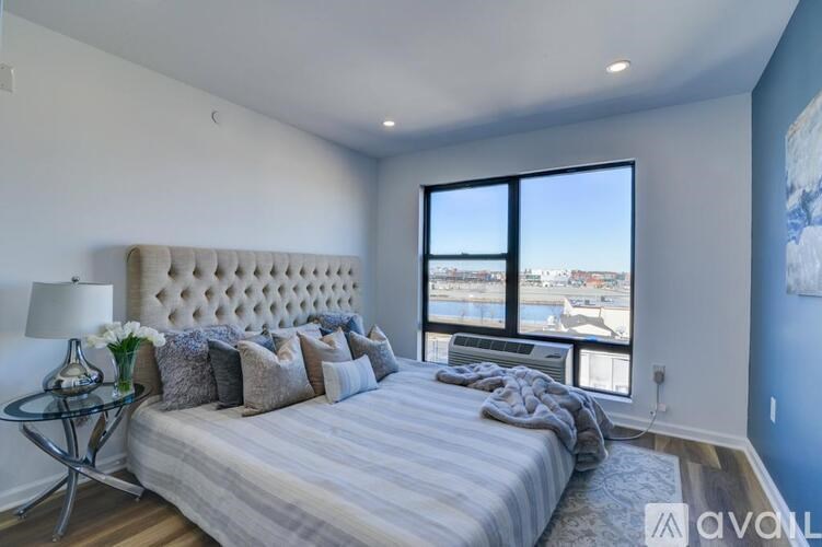 A bedroom with a large bed and a view of the water.