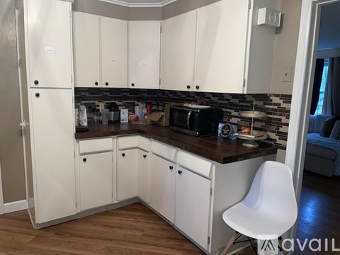 A kitchen with white cabinets and a wooden countertop.