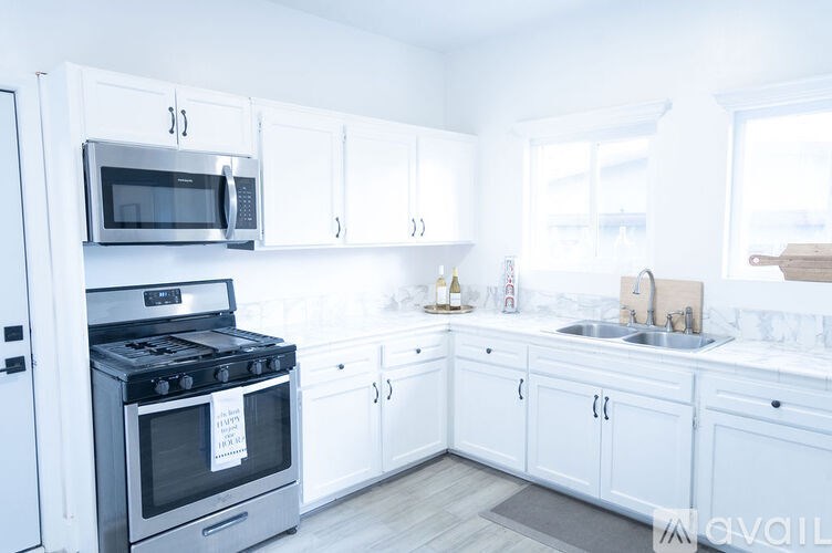 A kitchen with white cabinets and appliances.