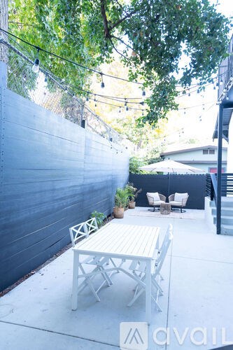 A patio with a white table and chairs is shown.