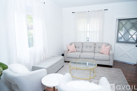 A living room with a grey couch and a white chair.
