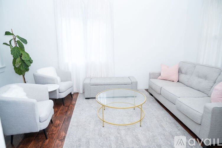 A living room with a grey couch, two chairs, and a coffee table.