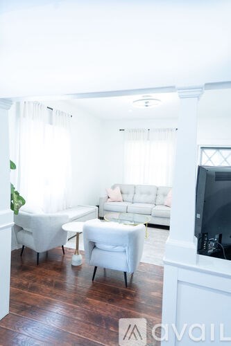 A living room with a white couch and a television.
