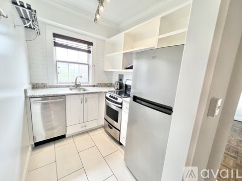 A kitchen with white appliances and cabinets.