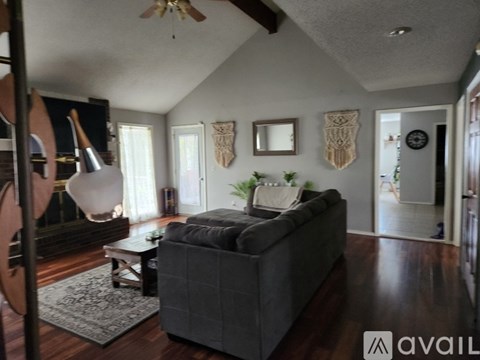 A living room with a grey couch and a wooden floor.