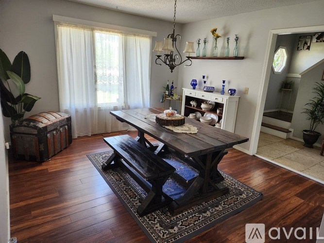 A dining room with a wooden table and chairs.