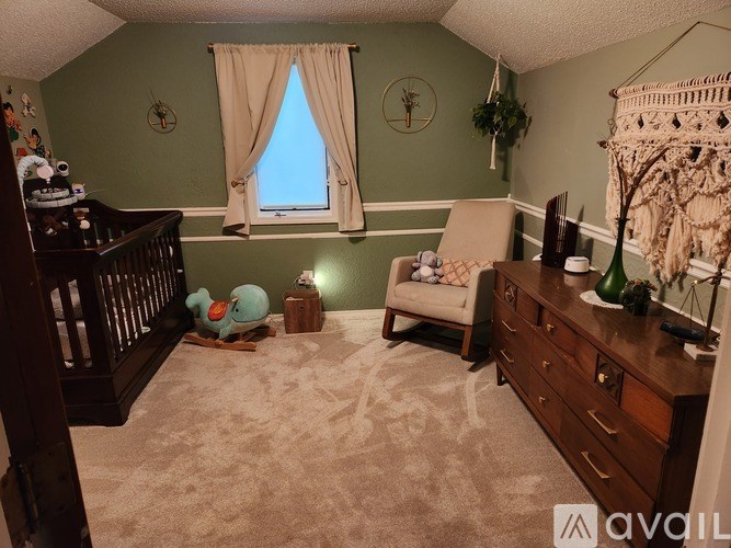 A baby's room with a crib, a chair, and a window.