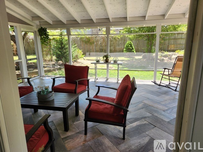 A patio with a table and chairs overlooking a backyard.