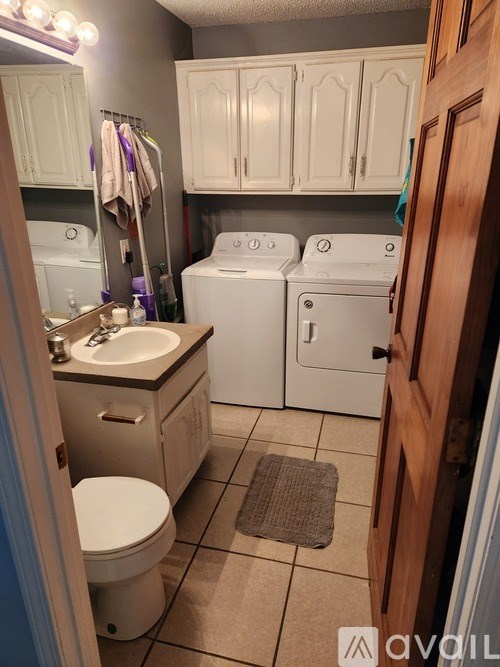 A small bathroom with a toilet, sink, and washing machine.