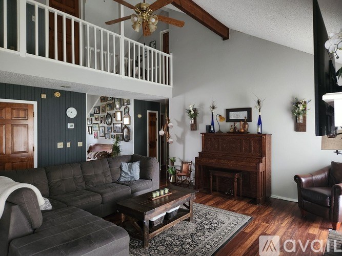 A living room with a grey sofa, wooden coffee table, and a wooden cabinet.