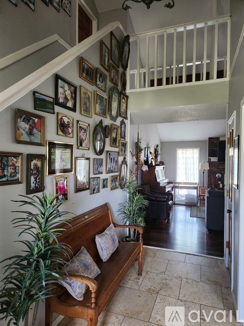 A living room with a couch and a wall of framed pictures.