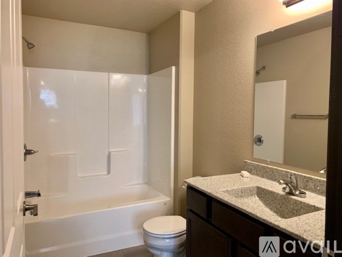 A bathroom with a white tub, toilet, and sink.