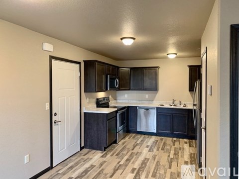 A kitchen with dark wood cabinets and a white door.