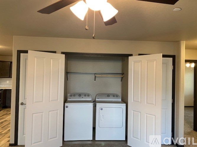 A laundry room with a ceiling fan and two washing machines.