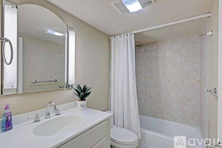 A bathroom with a white sink, toilet, and bathtub.