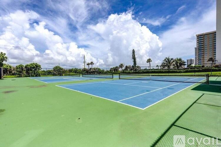 A tennis court with a blue and green surface and white lines marking the boundaries.