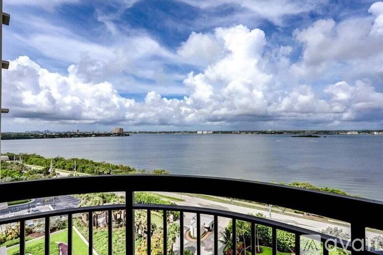 A balcony overlooks a body of water with a cloudy sky above.