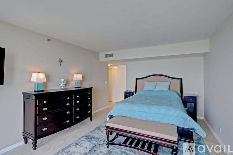 A bedroom with a bed, dresser, and nightstand.