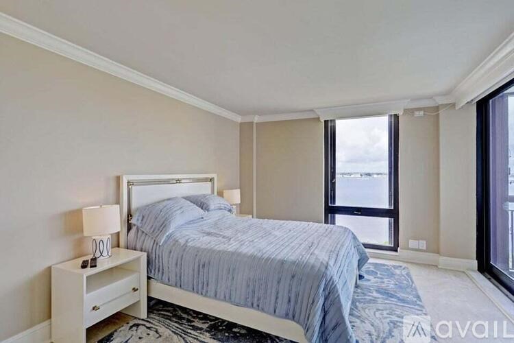 A bedroom with a bed, nightstand, and window.