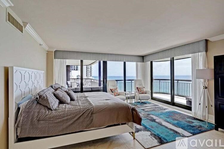 A bedroom with a large bed and a view of the ocean.