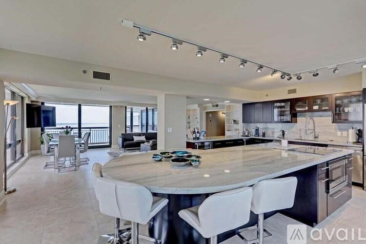 A modern kitchen with a large island and bar stools.