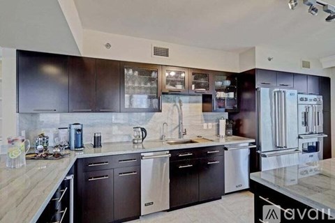 A kitchen with dark brown cabinets and stainless steel appliances.