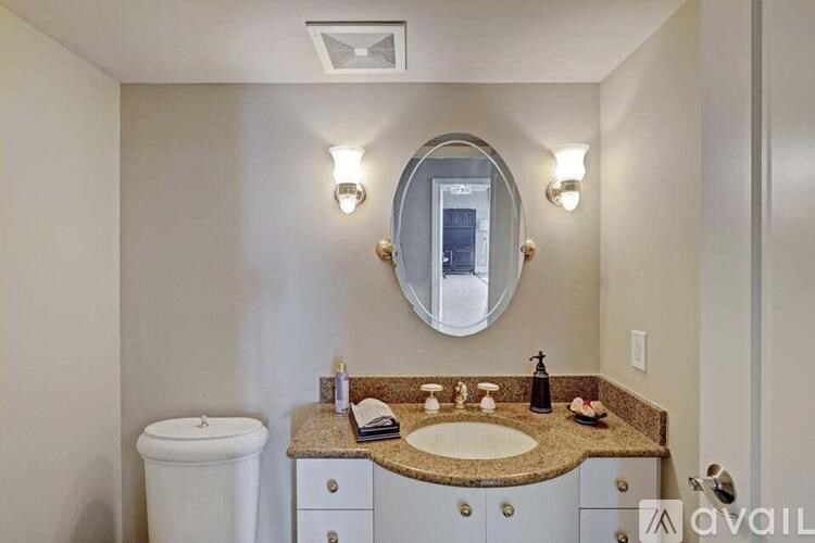 A bathroom with a toilet, sink, and mirror.