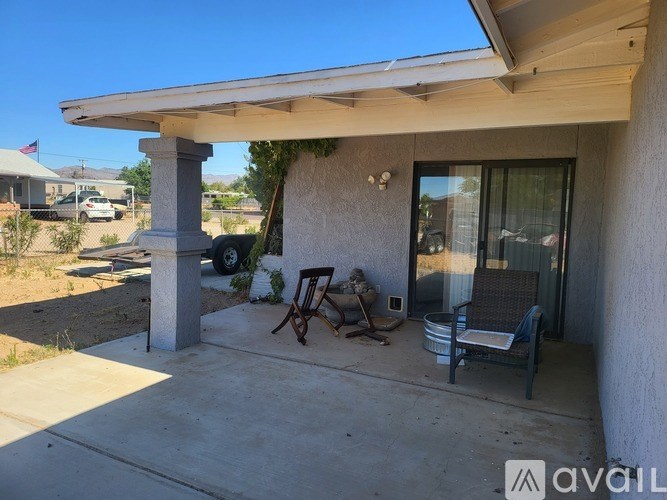 A patio with a table and chairs is covered by a roof.