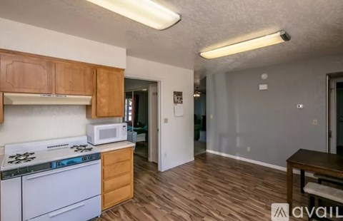 A kitchen with a white stove and wooden cabinets.