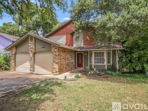 A house with a red door and a garage door is for sale.