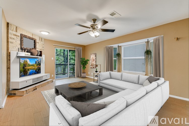 A living room with a white couch and a flat screen TV.