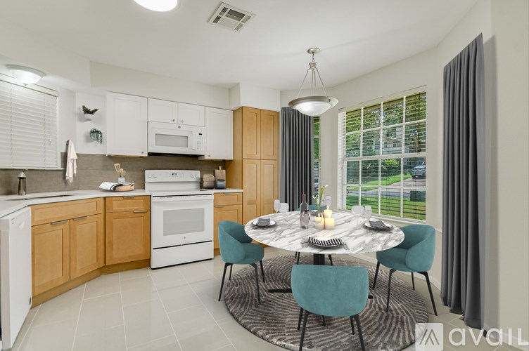 A modern kitchen with a dining table set for two.