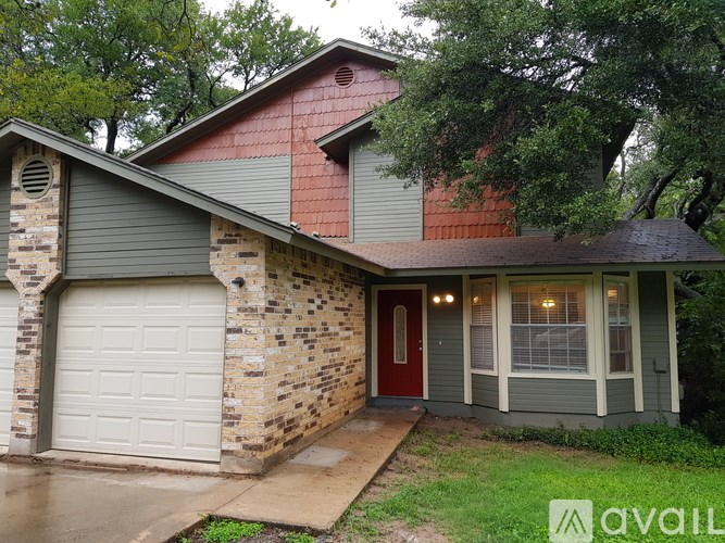 A house with a red door and a garage door.
