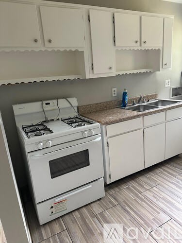 A white kitchen with a stove and sink.