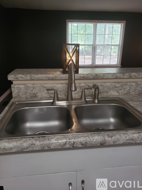 A kitchen sink with a granite counter top.