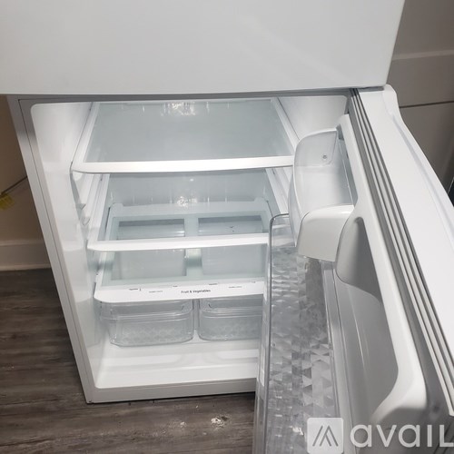 A white refrigerator with the door open and a drawer pulled out.