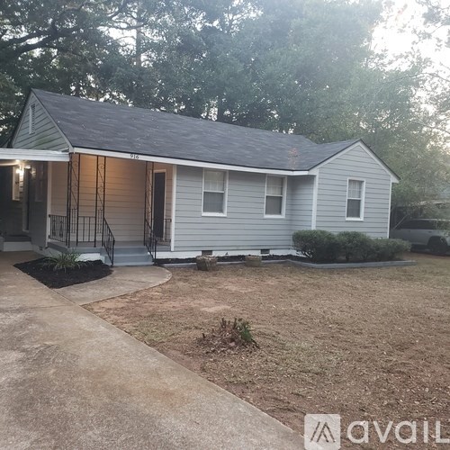 A house with a grey roof and a porch with a railing.