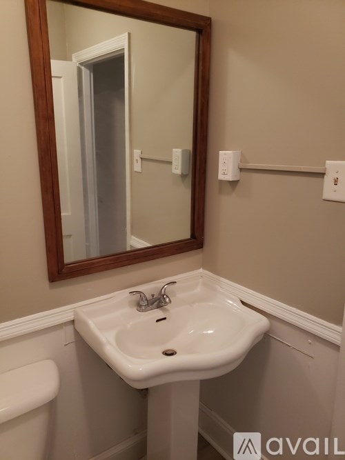 A bathroom with a sink, mirror, and toilet.