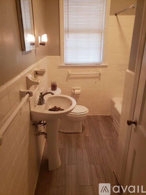 A bathroom with a toilet, sink, and window.