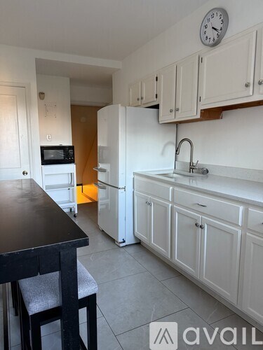 A kitchen with white cabinets and a black table.