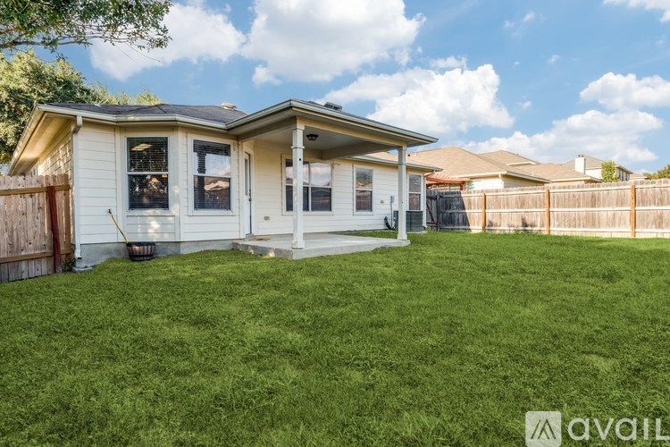 A house with a white exterior and a brown fence is for sale.
