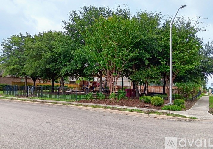 A street view with a sidewalk, trees, and a lamp post.