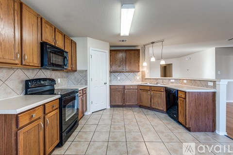 A kitchen with wooden cabinets and black appliances.