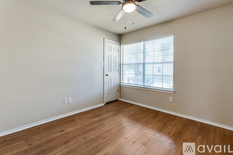 A room with a ceiling fan and a door leading to a balcony.
