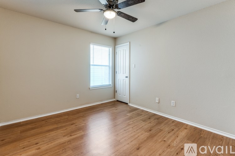 A room with a ceiling fan and wooden flooring.