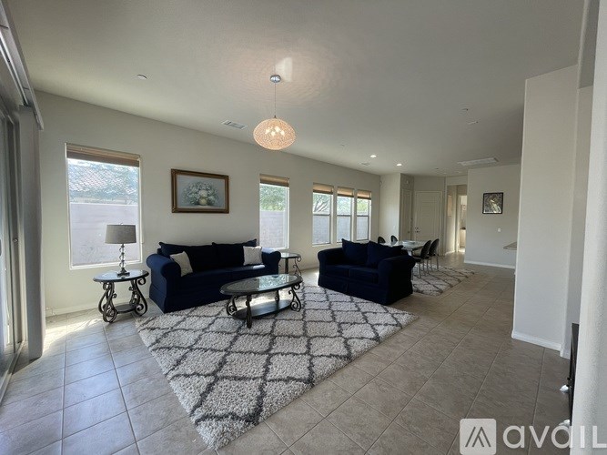 A living room with a dark blue sofa and a glass coffee table.