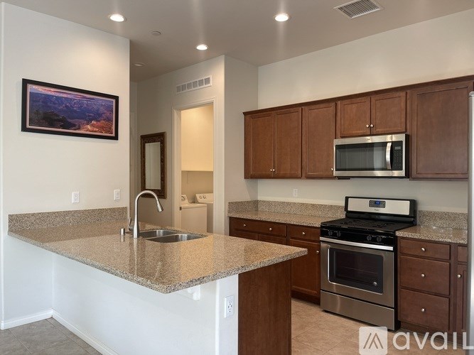 A kitchen with granite countertops and stainless steel appliances.